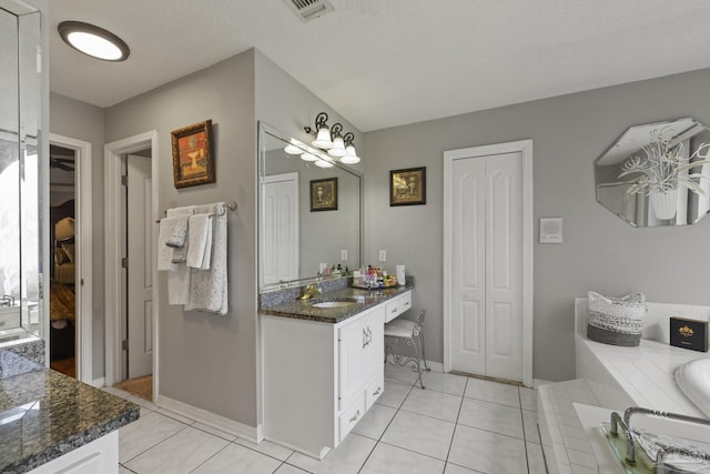 bathroom featuring vanity, a bathtub, and tile patterned floors