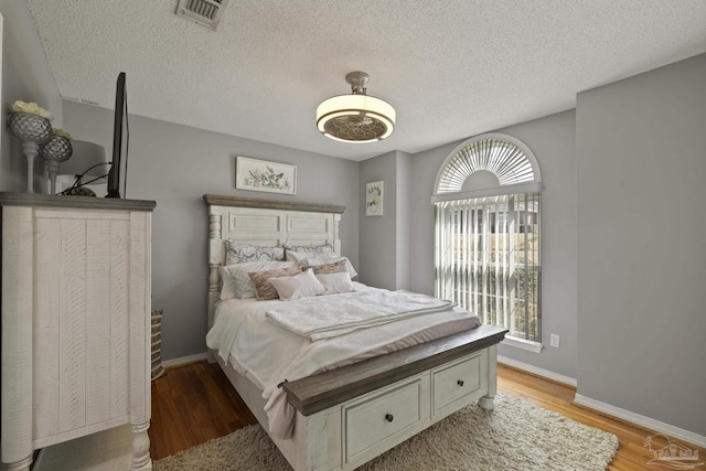 bedroom with a textured ceiling and light hardwood / wood-style flooring