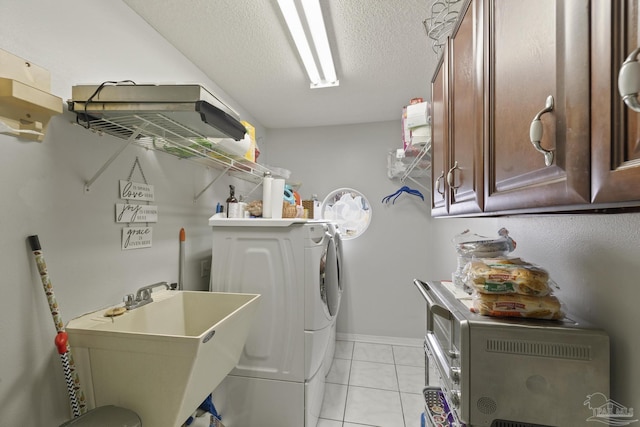 washroom with cabinets, sink, light tile patterned floors, and a textured ceiling