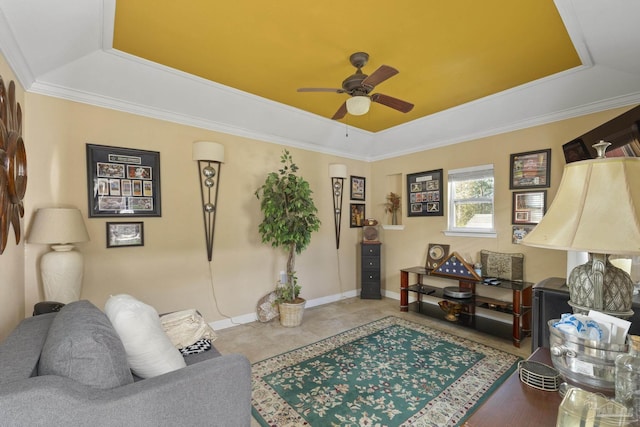 tiled living room with ceiling fan, ornamental molding, and a raised ceiling