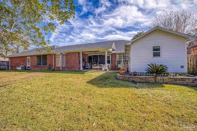 rear view of house featuring a yard