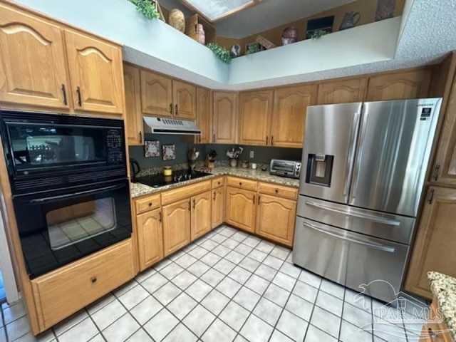 kitchen featuring black appliances, light tile patterned floors, and light stone counters