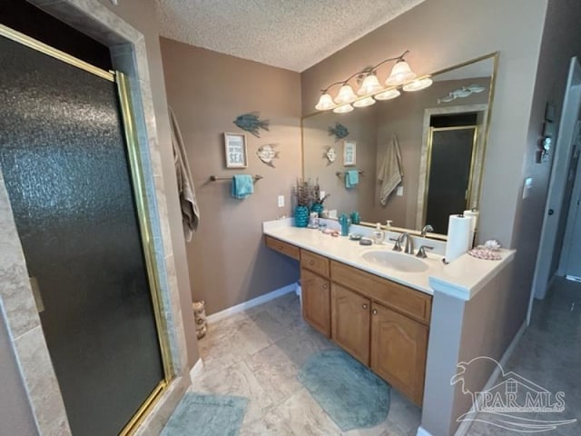 bathroom with vanity, an enclosed shower, tile patterned flooring, and a textured ceiling