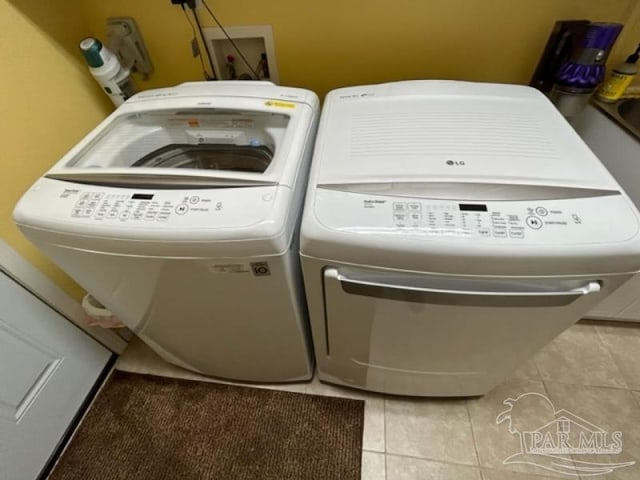 washroom with washer and clothes dryer and light tile patterned floors