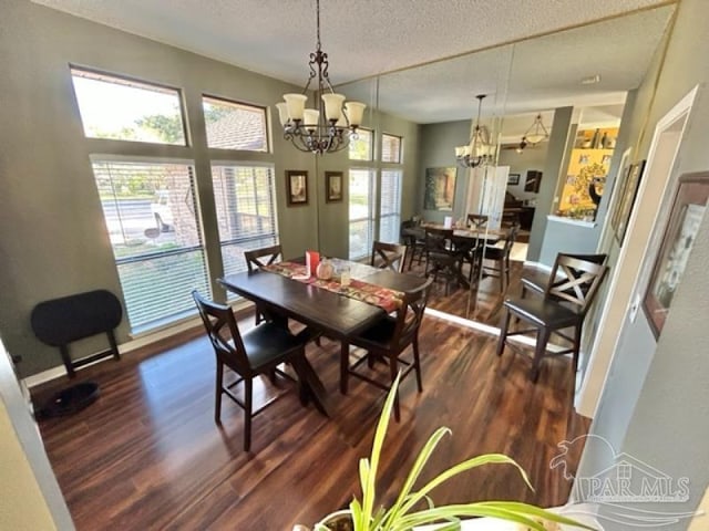 dining area featuring a textured ceiling, a chandelier, and dark wood-type flooring