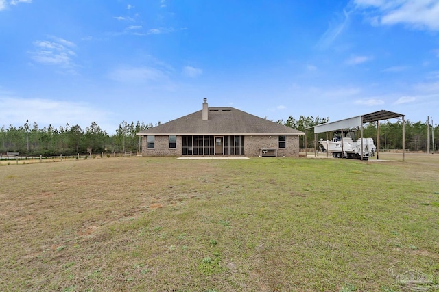 back of house with a carport, a sunroom, and a lawn