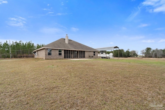 back of property with a yard and a carport