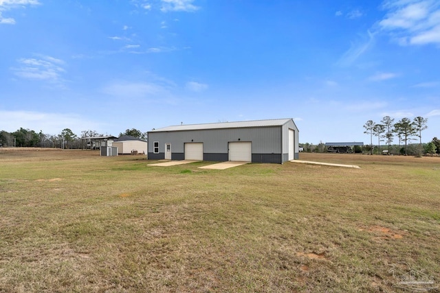 rear view of property featuring an outbuilding, a garage, and a yard