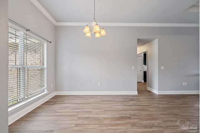 unfurnished room featuring hardwood / wood-style flooring, ornamental molding, and a chandelier