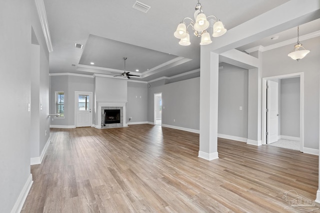 unfurnished living room featuring crown molding, light hardwood / wood-style floors, ceiling fan, and a tray ceiling