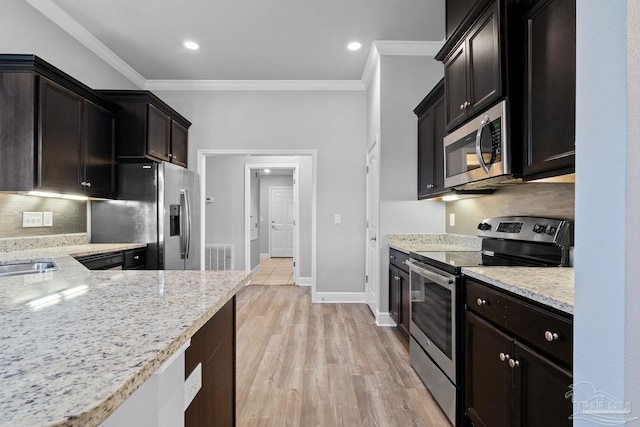 kitchen with ornamental molding, appliances with stainless steel finishes, light stone countertops, and decorative backsplash