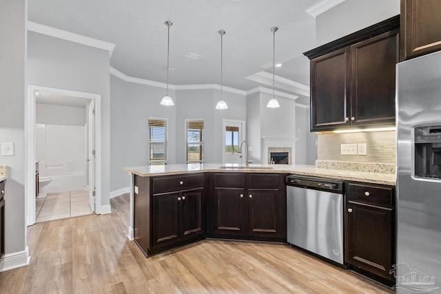 kitchen with hanging light fixtures, appliances with stainless steel finishes, sink, and dark brown cabinets