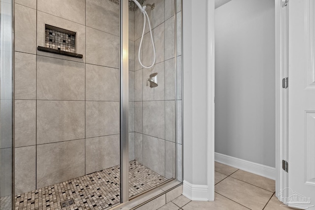 bathroom with an enclosed shower and tile patterned floors