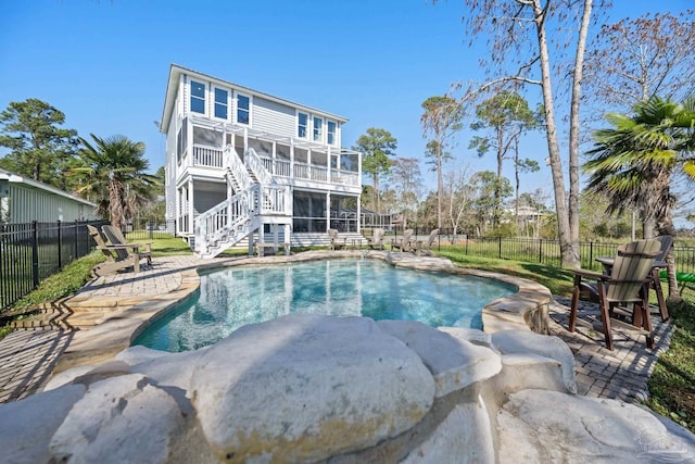 back of house featuring a patio, fence, a sunroom, stairway, and a fenced in pool