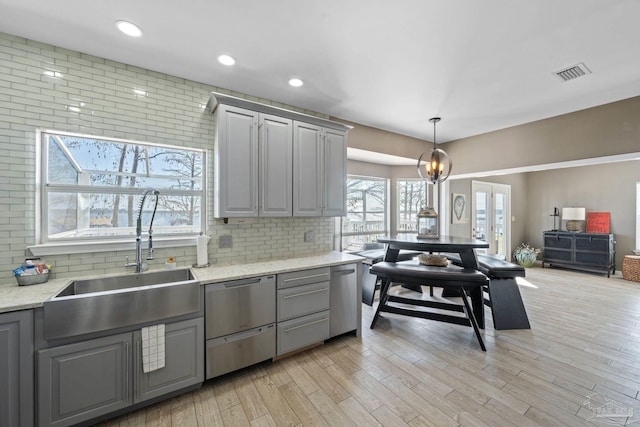 35868 Boykin Blvd, Lillian, AL 36549 - kitchen featuring backsplash, hanging light fixtures, a sink, gray cabinets, and stainless steel dishwasher