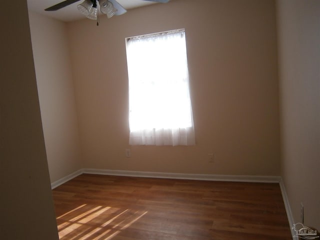 unfurnished room featuring ceiling fan, a wealth of natural light, and dark hardwood / wood-style floors