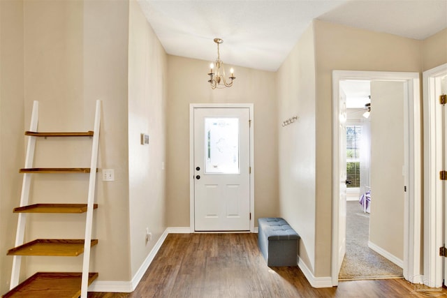 entrance foyer featuring hardwood / wood-style floors, vaulted ceiling, and ceiling fan with notable chandelier