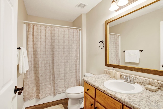 full bathroom featuring vanity, toilet, hardwood / wood-style flooring, and shower / tub combo