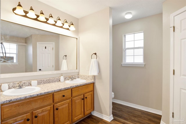 bathroom with vanity, toilet, a healthy amount of sunlight, and hardwood / wood-style floors