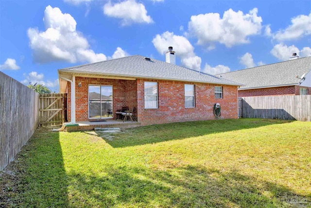 rear view of house featuring a lawn