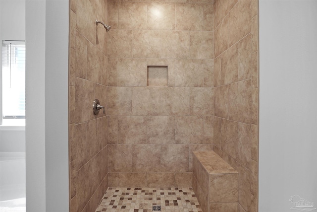 bathroom with a tile shower and plenty of natural light