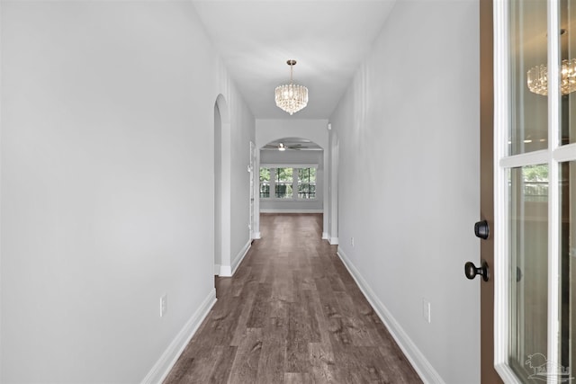 hallway featuring a notable chandelier and dark hardwood / wood-style floors