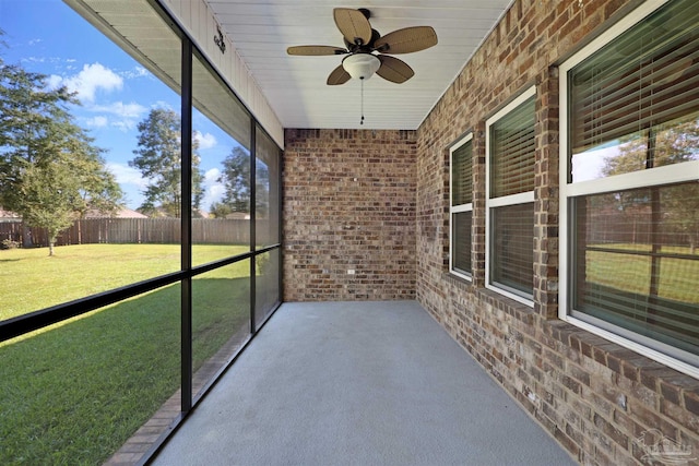 unfurnished sunroom with ceiling fan