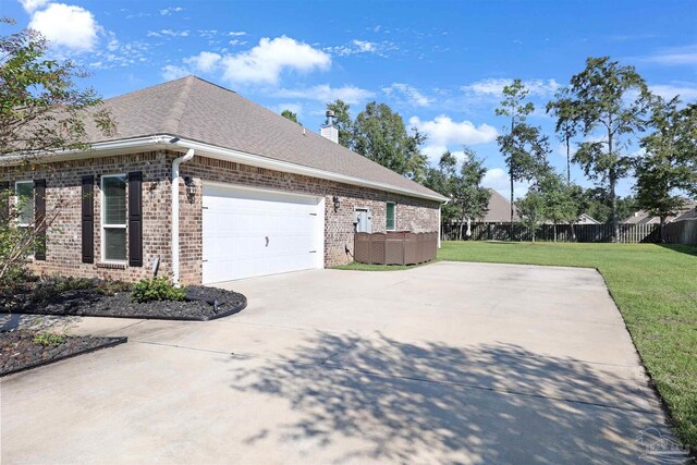 view of home's exterior featuring a garage and a lawn