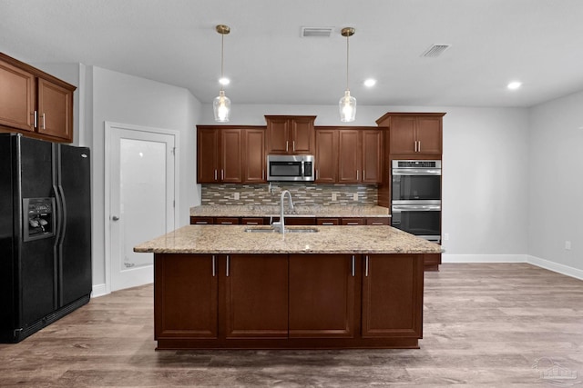 kitchen with light hardwood / wood-style floors, pendant lighting, tasteful backsplash, sink, and stainless steel appliances