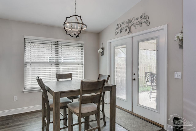 dining room with french doors, vaulted ceiling, dark hardwood / wood-style floors, and a chandelier