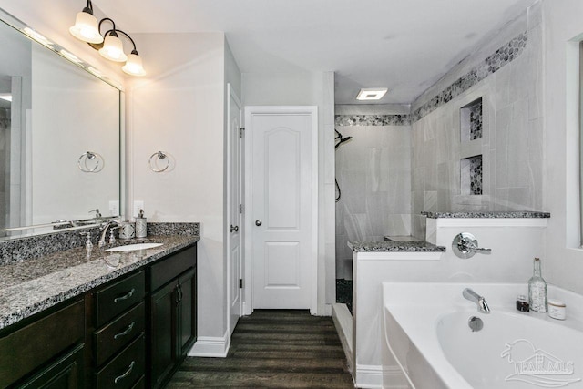 bathroom featuring vanity, plus walk in shower, and hardwood / wood-style flooring