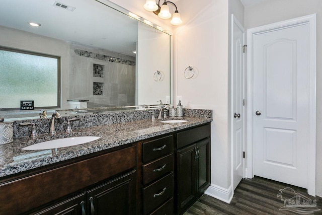 bathroom featuring vanity, tiled shower, and hardwood / wood-style floors