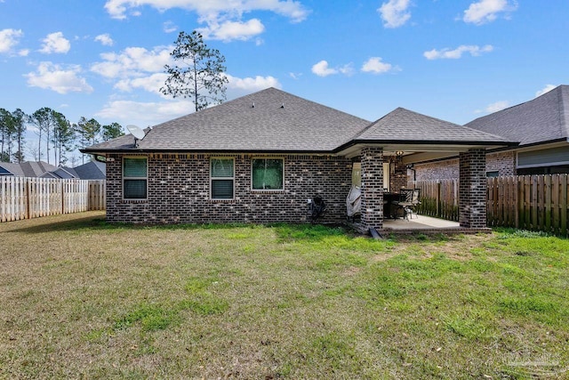 back of house with a patio area and a lawn