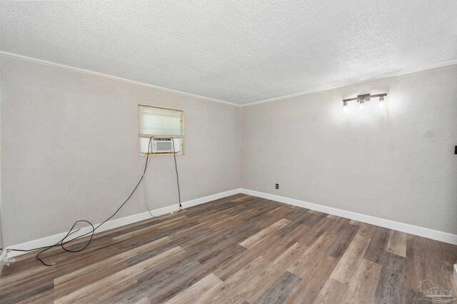 unfurnished room featuring cooling unit, a textured ceiling, crown molding, and dark hardwood / wood-style flooring