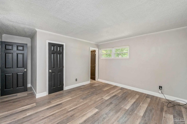 unfurnished bedroom featuring wood-type flooring, a textured ceiling, and crown molding