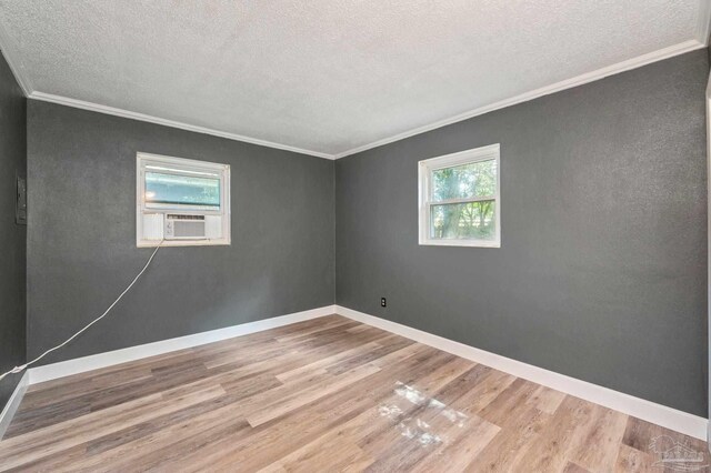 spare room with a textured ceiling, ornamental molding, and hardwood / wood-style floors