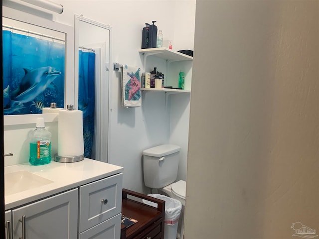 bathroom featuring a shower with curtain, vanity, and toilet