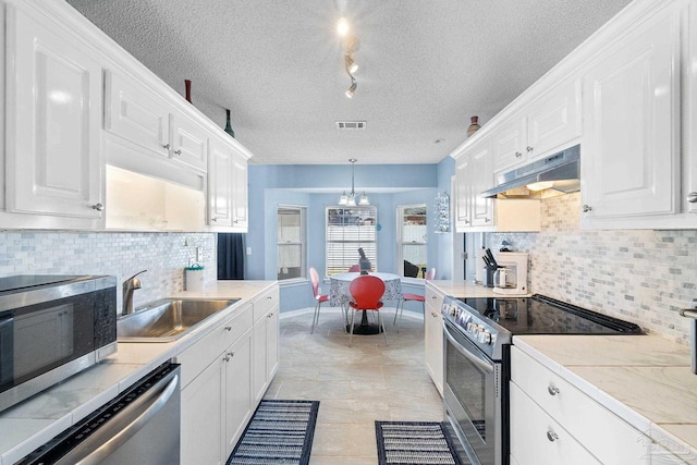 kitchen with appliances with stainless steel finishes, white cabinets, a sink, and under cabinet range hood