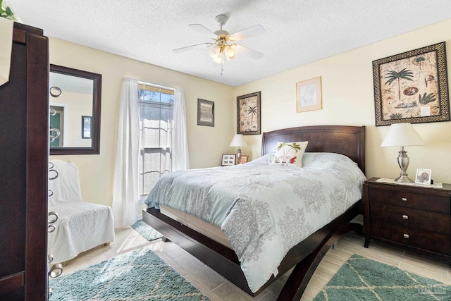 bedroom with a textured ceiling, access to outside, light wood-type flooring, and a ceiling fan