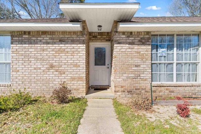 entrance to property featuring brick siding