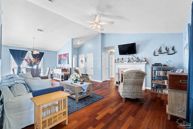 living area featuring lofted ceiling, a fireplace with flush hearth, a textured ceiling, and wood finished floors