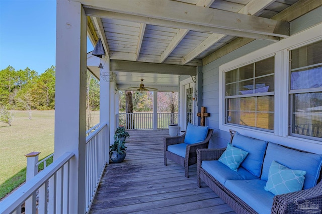 wooden terrace featuring a lawn and a porch