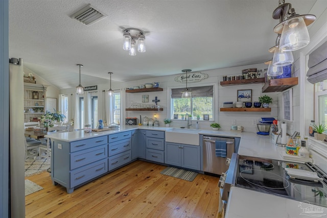 kitchen featuring light countertops, visible vents, stainless steel appliances, a sink, and open shelves