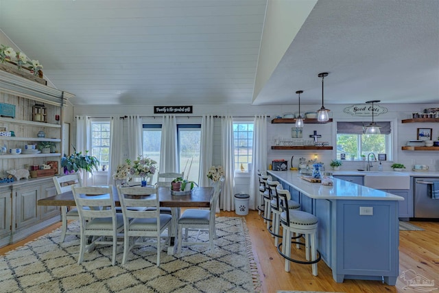 dining space featuring vaulted ceiling and light wood-style flooring