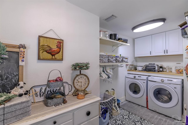 laundry room with cabinet space, visible vents, and separate washer and dryer