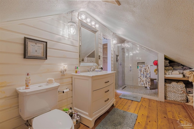 full bathroom with a stall shower, hardwood / wood-style flooring, lofted ceiling, and a textured ceiling