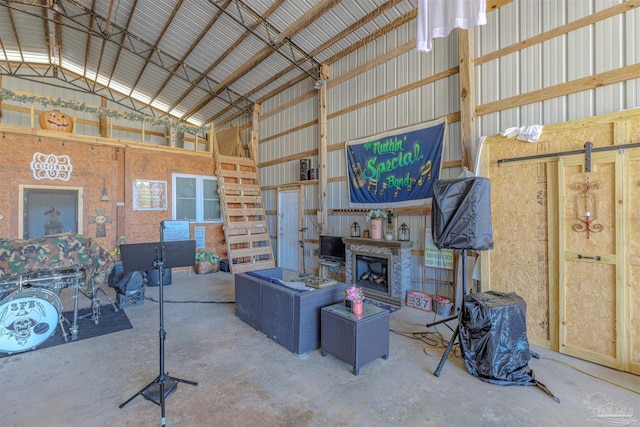 living area with unfinished concrete floors, a fireplace with raised hearth, and metal wall