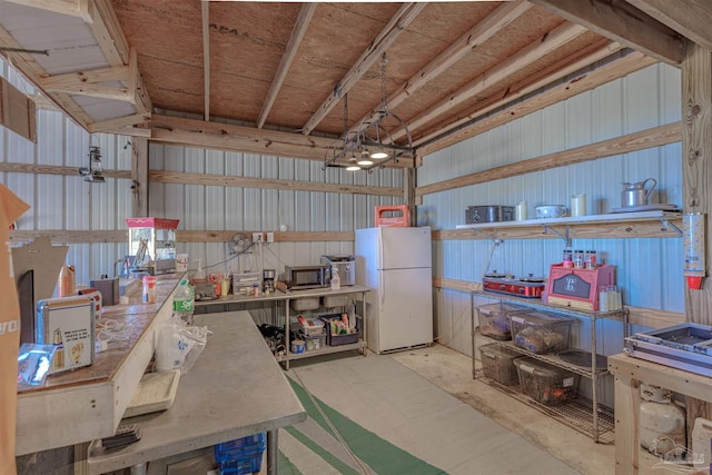 garage with metal wall and freestanding refrigerator