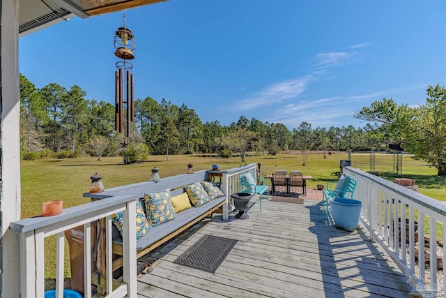 deck featuring outdoor dining space and a lawn