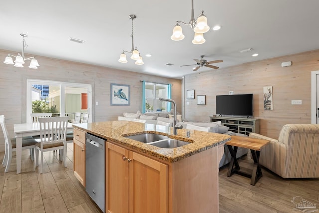 kitchen featuring a wealth of natural light, dishwasher, a kitchen island with sink, and sink